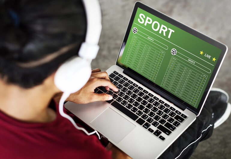 A man listening to music while placing sports bets on a Toto site