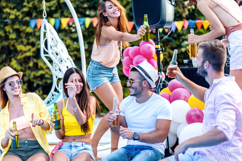 Group of young women enjoying a music festival with drinks in hand