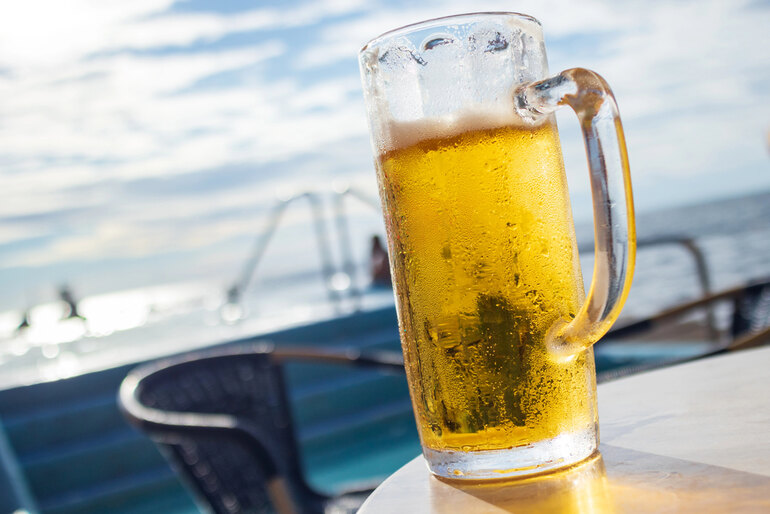 Frosty mug of beer on an outdoor table overlooking the ocean in Carlsbad