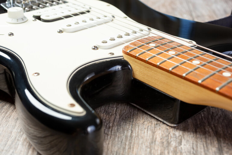 Close-up of electric guitar body and neck showing pickup, bridge, and fretboard details