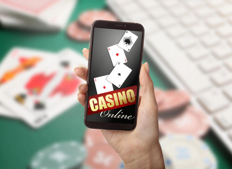 A girl’s hand holding a mobile phone with an online casino app open on the screen