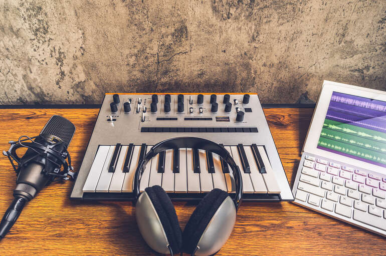 Audio production setup with keyboard, headphones, and microphone to separate vocals from music for free