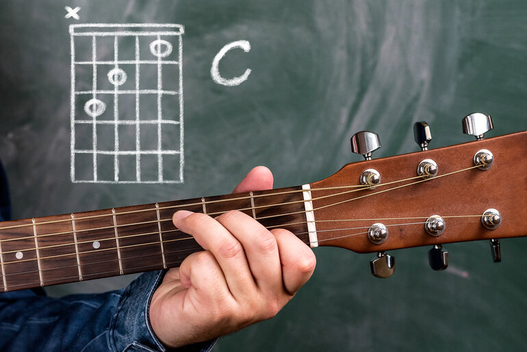 A student learning guitar as part of music education