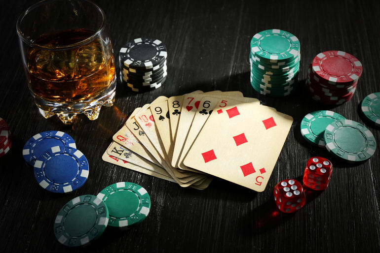 Close-up of playing cards, poker chips, dice on a dark table, gambling activities, and addiction