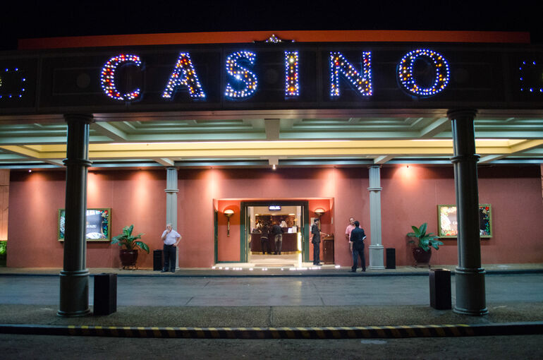 Night view of a California casino entrance lit up with colorful lights