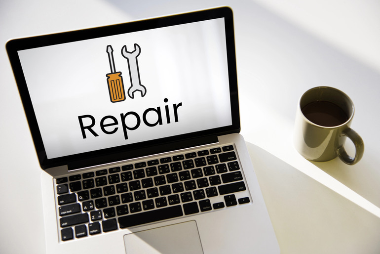 Laptop screen displaying repair icon with screwdriver and wrench, symbolizing online reputation repair services for musicians and public figures