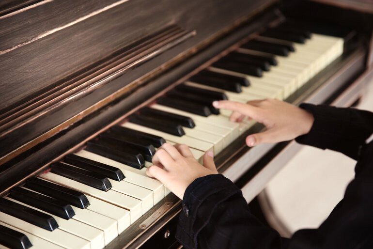 Child playing piano as part of the Premium Piano Program for busy families in Arlington, Falls Church, and McLean