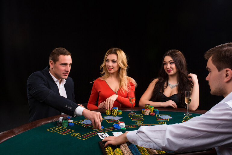 A Group of friends playing cards and betting with chips at a casino, and enjoying live music.