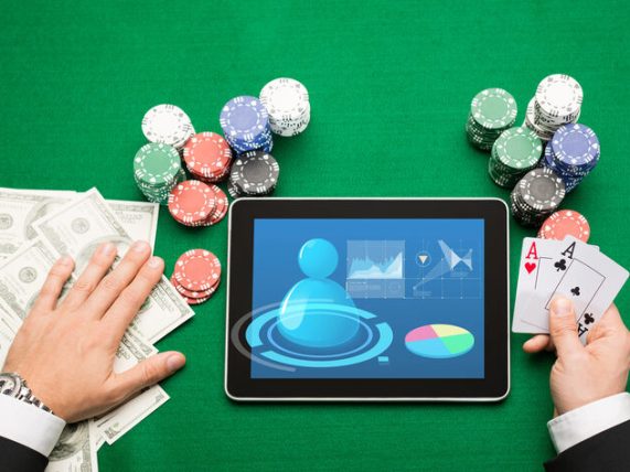 Online casino setup with cash chips, tablet, and playing cards illustrating deposits and withdrawals for music fans.