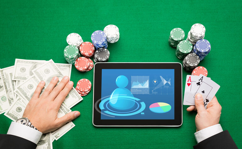Online casino setup with cash chips, tablet, and playing cards illustrating deposits and withdrawals for music fans.
