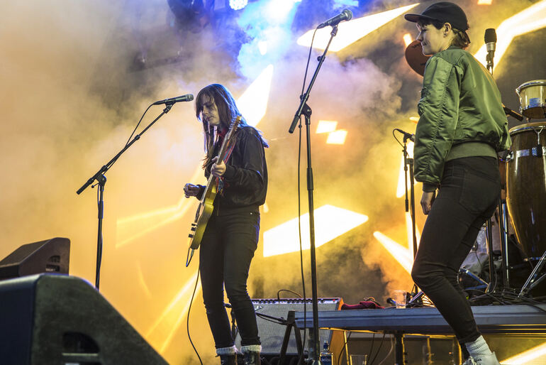 Emerging artists performing live on stage with vibrant lights and atmospheric smoke.