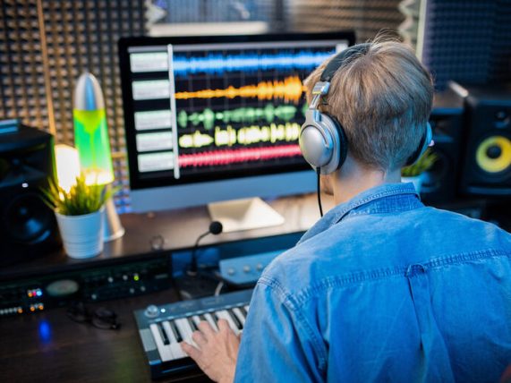 Music producer who uses dynamic effects of whoosh sounds and the rising audio waveforms on a studio screen.