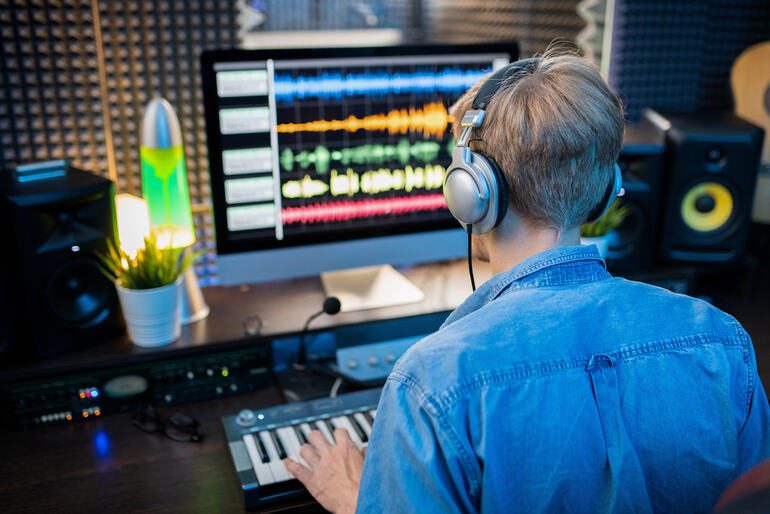 Music producer who uses dynamic effects of whoosh sounds and the rising audio waveforms on a studio screen.
