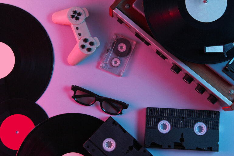 A video game controller with vinyl records, cassette tapes, and a turntable
