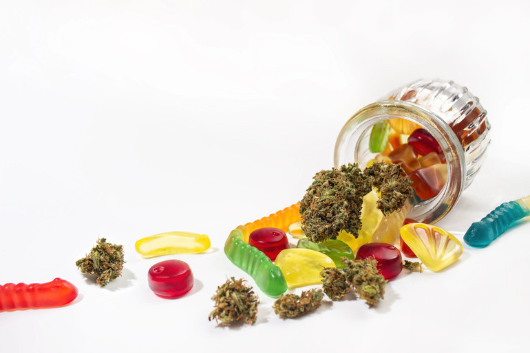 Various gummies and dried marijuana buds fell out of the embossed glass jar