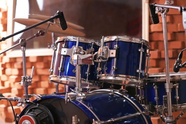 Professional drum kit with microphones set up in a recording studio for drummers practicing and recording music