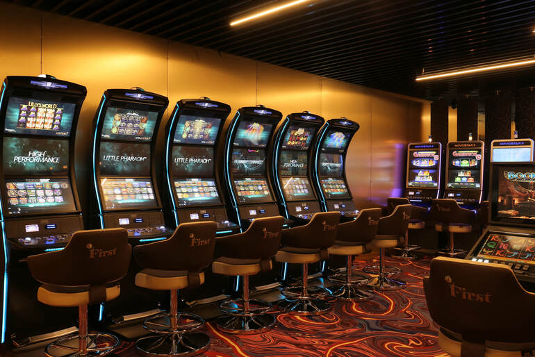 A row of officially branded music-themed slot machines glowing in a modern casino