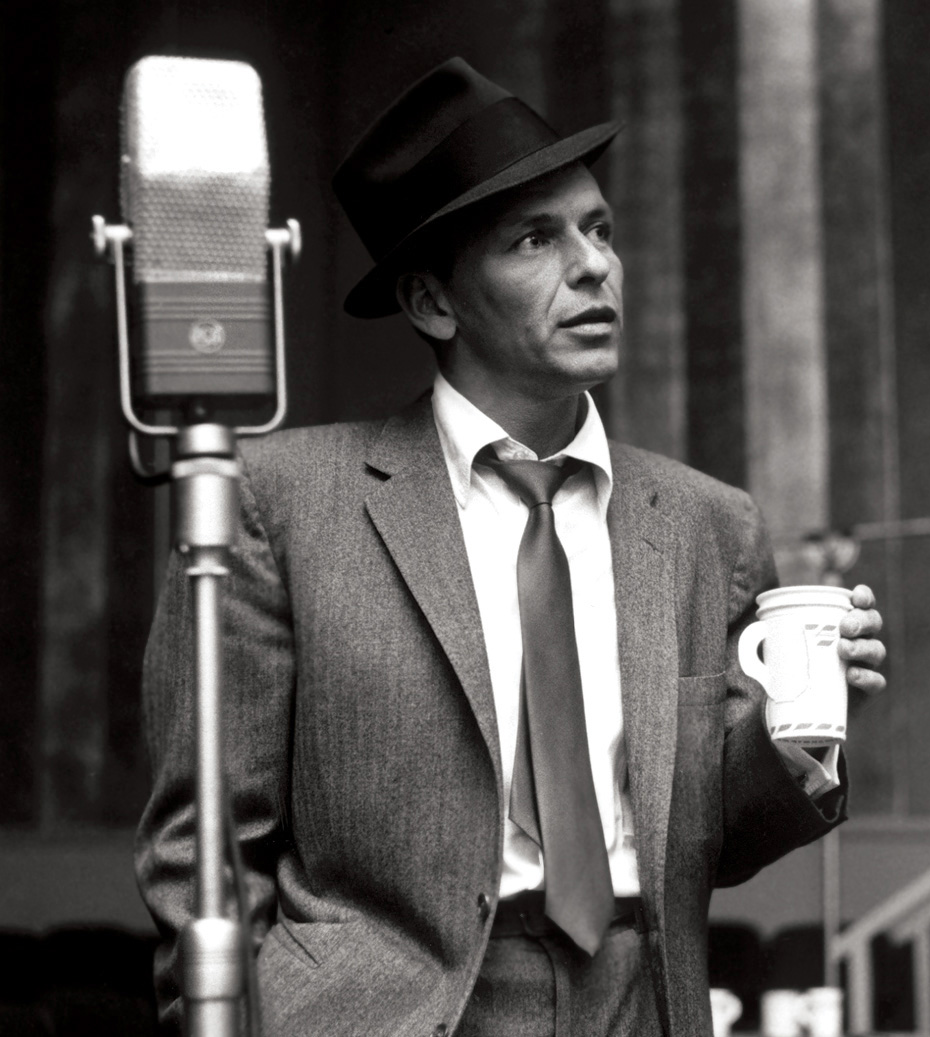 Frank Sinatra recording new material in the studio with a coffee cup in hand.