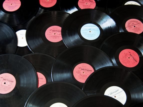 Colorful vintage vinyl records celebrating album anniversaries in 2026, arranged in bins, photographed from above.