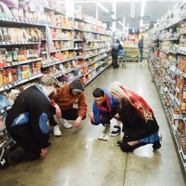Members of They are Gutting a Body of Water playing dice in a grocery store aisle