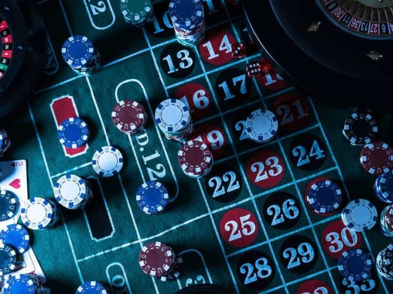Roulette table with casino chips placed on numbered betting grid, representing gambling risk and reward theme.