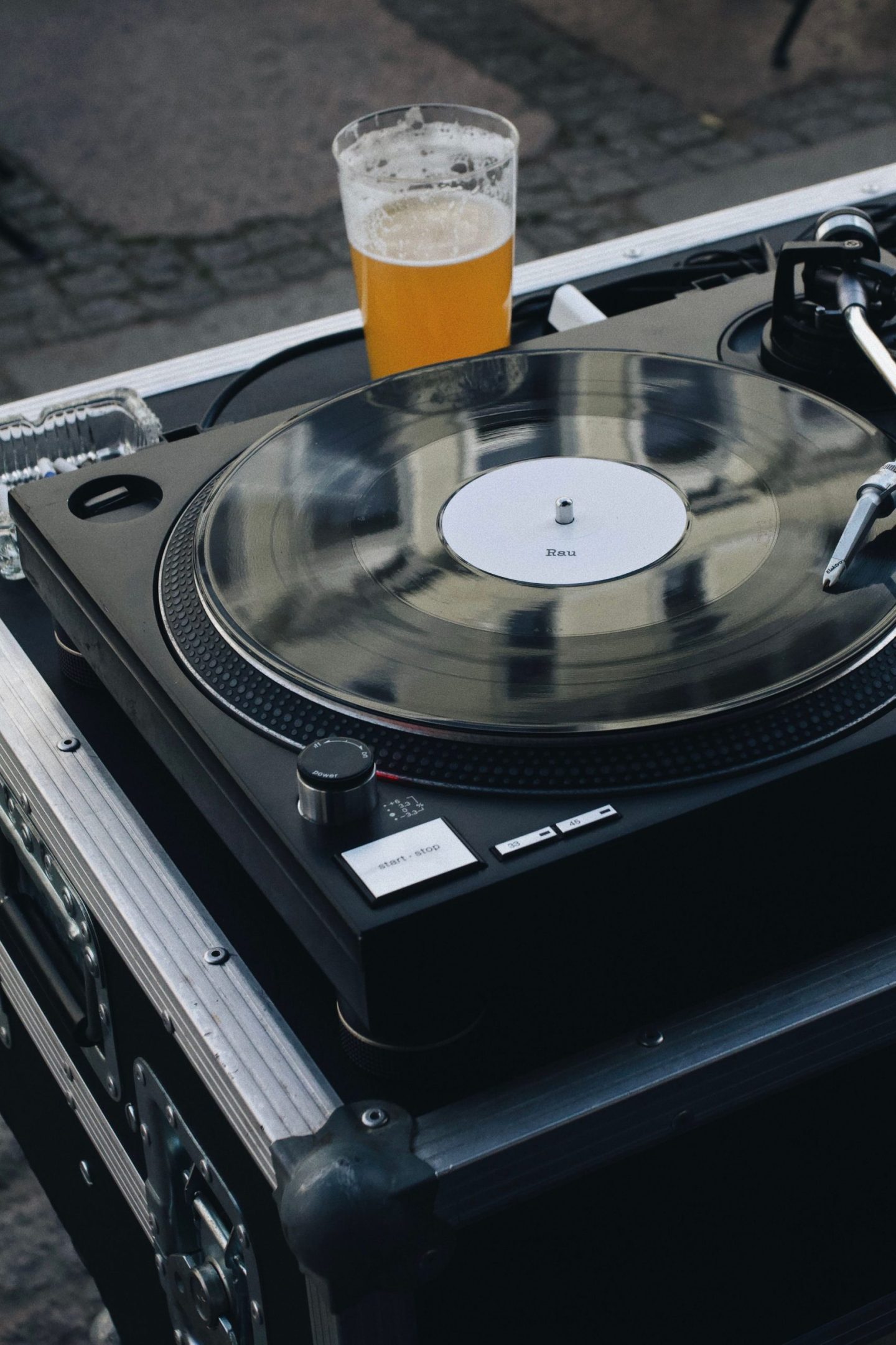 Turntable playing some of the best beer songs with a beer sitting next to it.