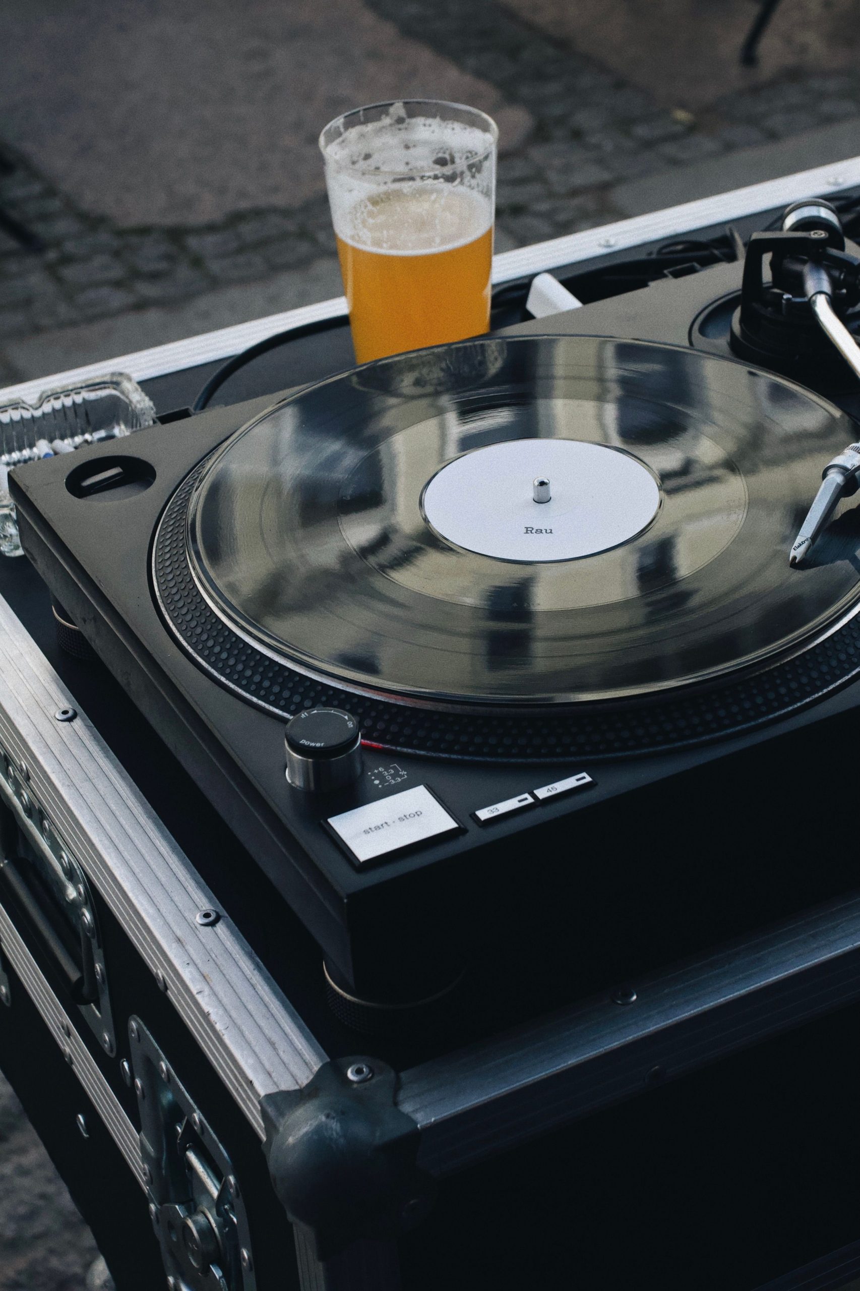 Turntable playing some of the best beer songs with a beer sitting next to it.
