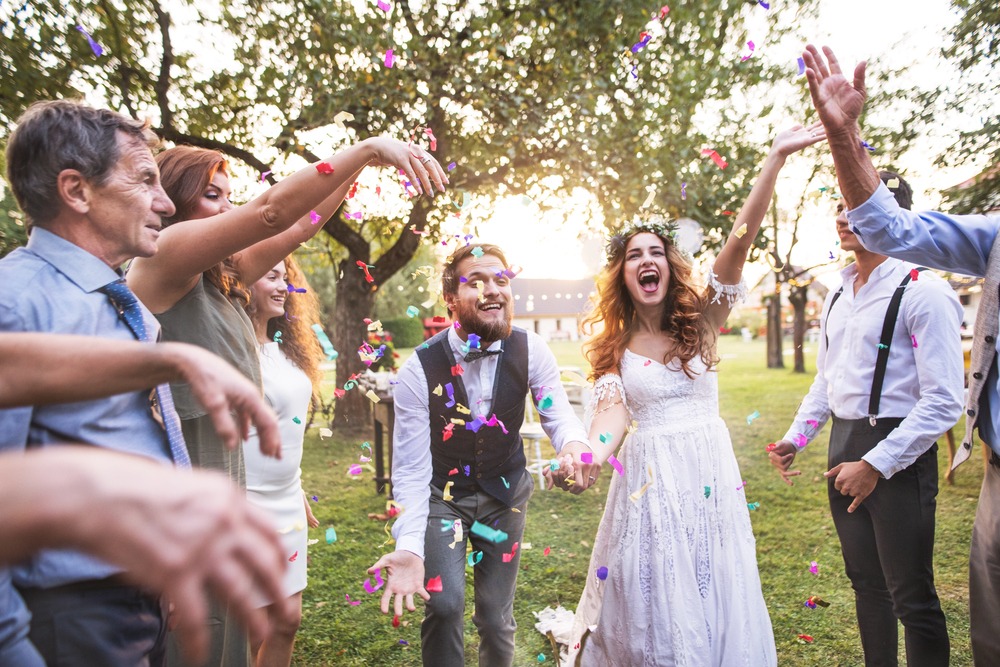Wedding Reception Celebration With Guests Throwing Confetti Outdoors