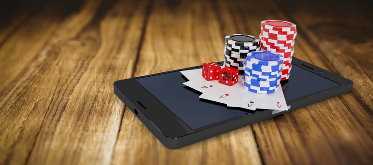 Online casino gaming displayed on a tablet with poker chips, playing cards, and dice, representing digital casino entertainment.