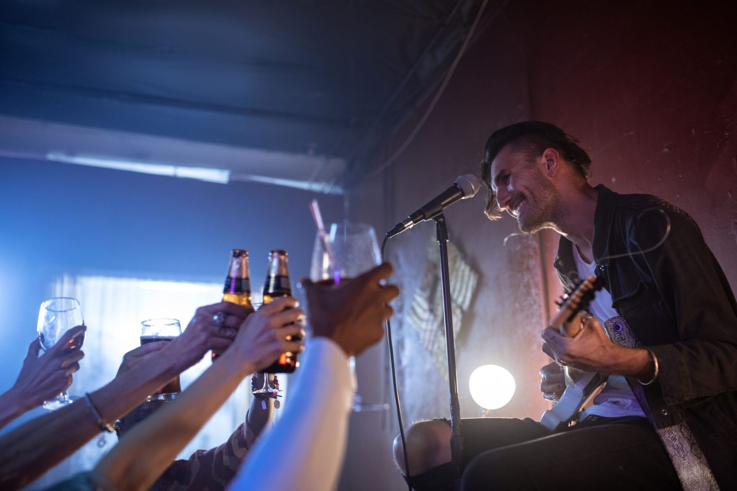 A man performing drinking songs while others toast around him