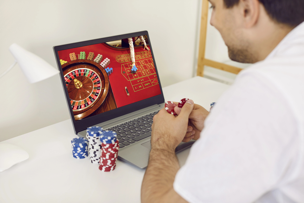 A man playing online casino on his laptop.
