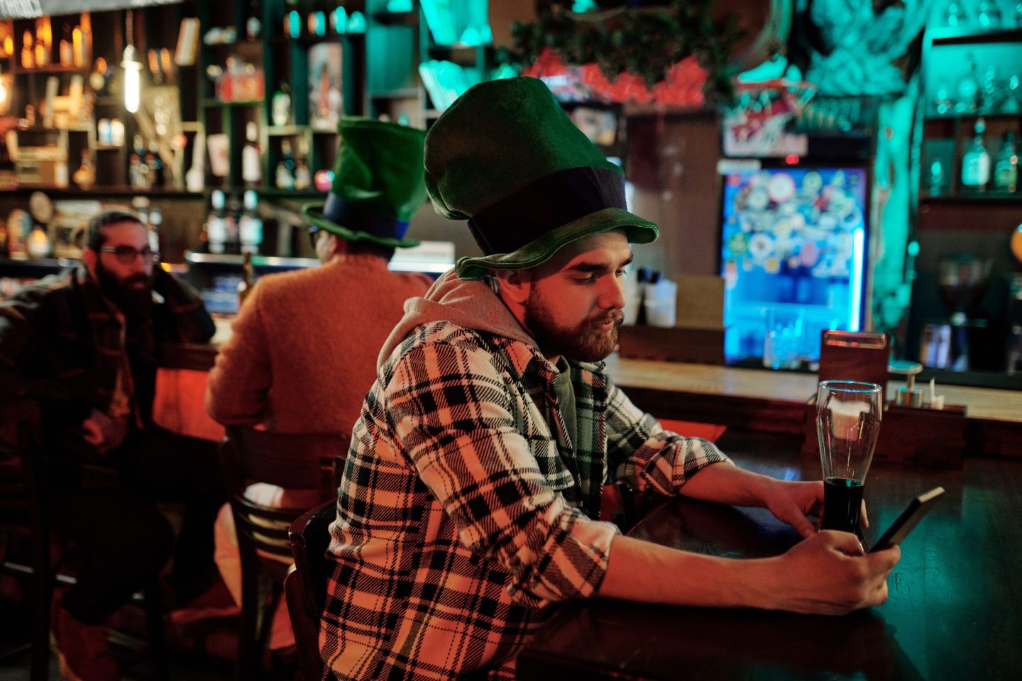 Man with Irish hat sits at the bar looking sad.