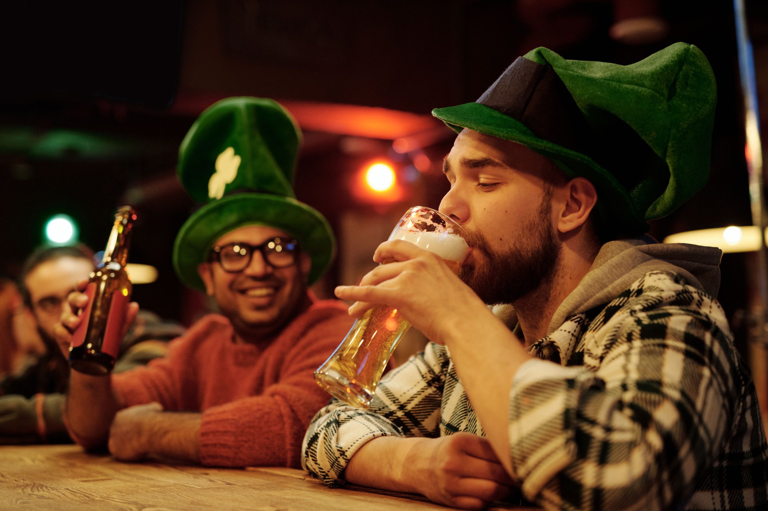 Two men sitting at a table drinking to irish drinking songs