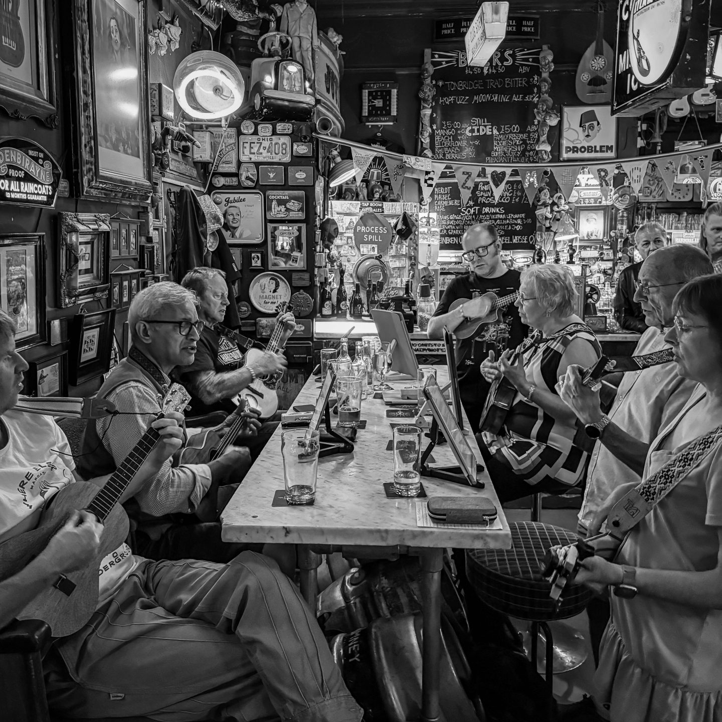 Black and white photo of a group of people in an Irish pub playing Irish drinking songs.