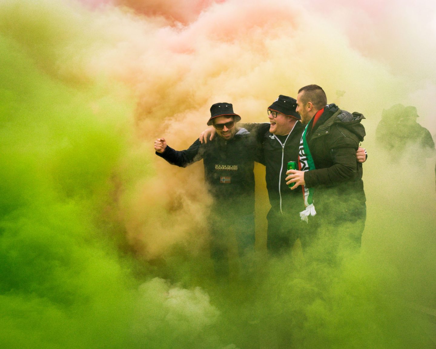 Group of Irish men dance amid green and red smoke